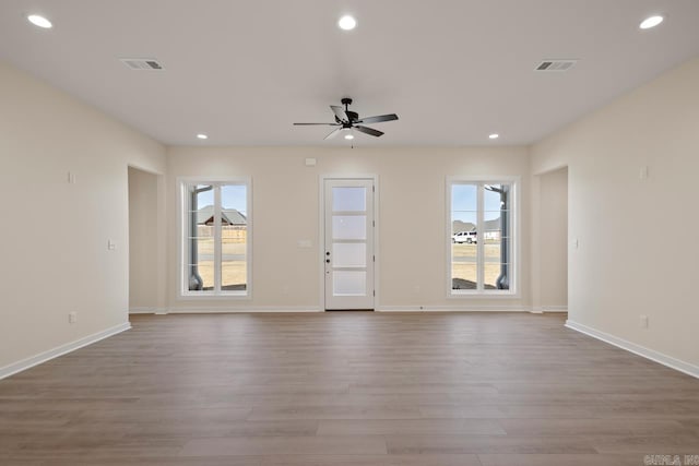 unfurnished living room with recessed lighting and visible vents