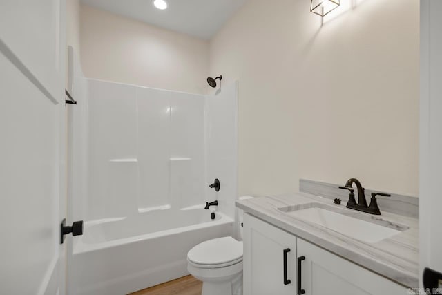 full bath with washtub / shower combination, wood finished floors, vanity, and toilet