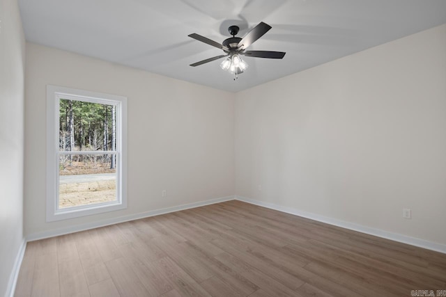 spare room featuring a ceiling fan, baseboards, and wood finished floors