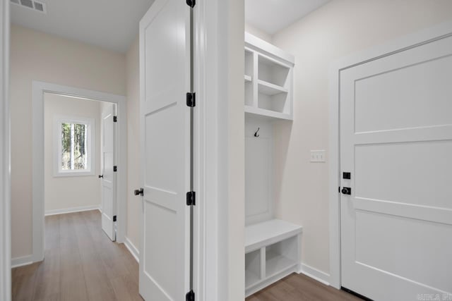 mudroom featuring visible vents, baseboards, and wood finished floors