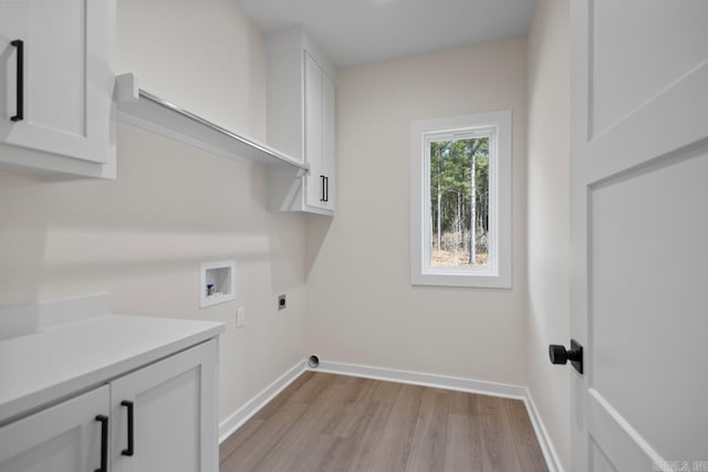 laundry area with cabinet space, baseboards, light wood-style floors, washer hookup, and electric dryer hookup