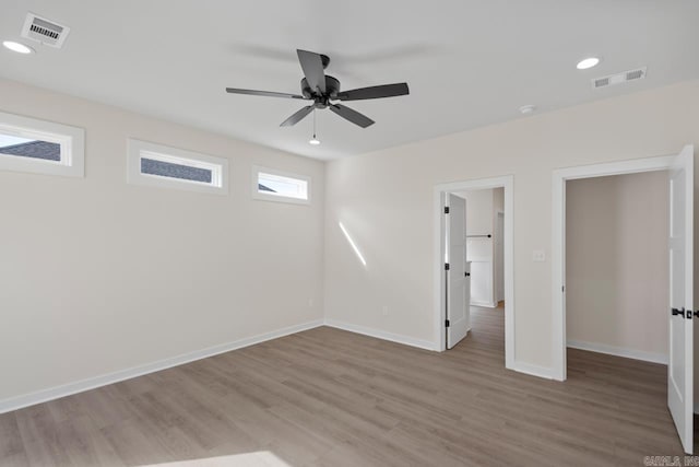 unfurnished room featuring light wood-style floors, baseboards, visible vents, and recessed lighting