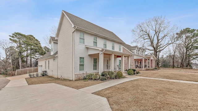 view of front of home with fence, a porch, and brick siding