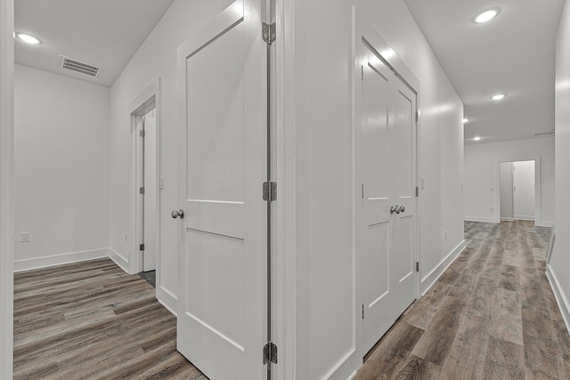 corridor with recessed lighting, visible vents, and wood finished floors