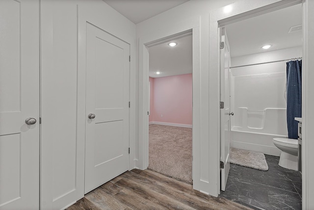 hallway featuring baseboards, visible vents, dark wood-type flooring, and recessed lighting