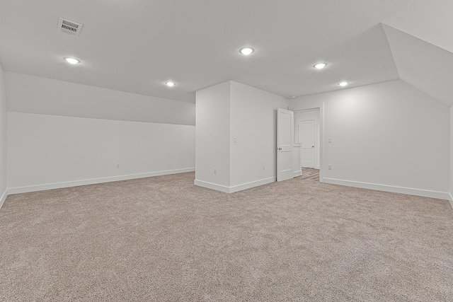 additional living space with lofted ceiling, recessed lighting, visible vents, light carpet, and baseboards