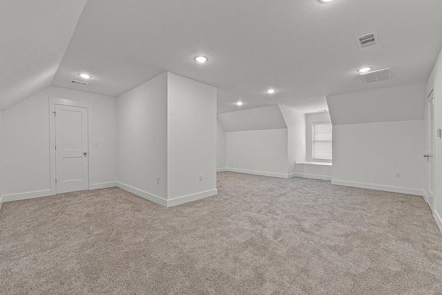 bonus room with light carpet, baseboards, and visible vents