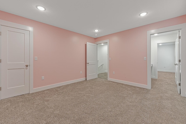 unfurnished bedroom featuring light carpet, recessed lighting, and baseboards