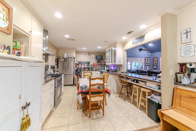 kitchen featuring light tile patterned floors, visible vents, appliances with stainless steel finishes, and exhaust hood