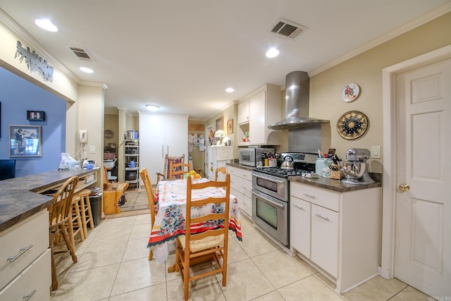 kitchen with stainless steel appliances, visible vents, ornamental molding, wall chimney exhaust hood, and dark countertops