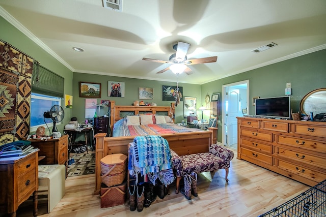 bedroom featuring wood finished floors, visible vents, and crown molding