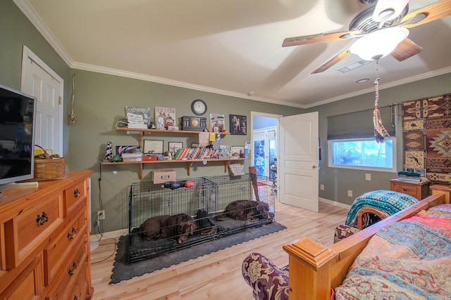 bedroom with ceiling fan, light wood finished floors, baseboards, and crown molding