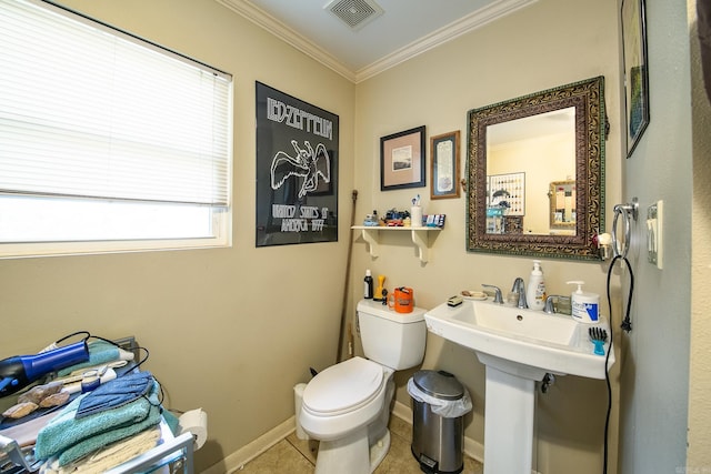 half bath with toilet, visible vents, baseboards, ornamental molding, and tile patterned floors