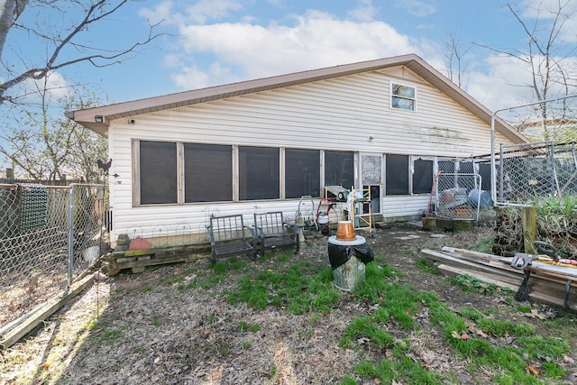 rear view of property with a sunroom and fence