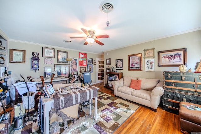 living area featuring visible vents, crown molding, and wood finished floors