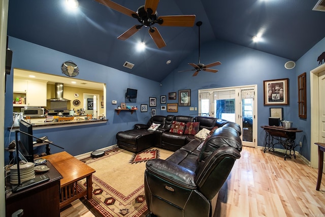 living room featuring high vaulted ceiling, baseboards, visible vents, and wood finished floors