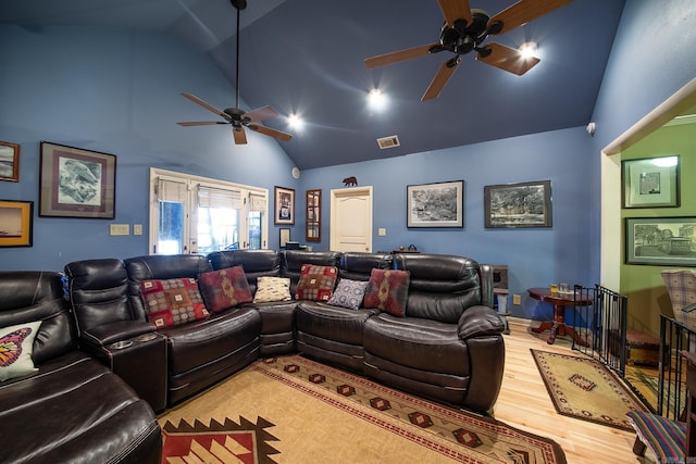 home theater room with a ceiling fan, visible vents, high vaulted ceiling, and wood finished floors