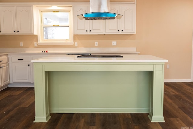 kitchen featuring cooktop, island range hood, a kitchen island, dark wood-type flooring, and white cabinetry