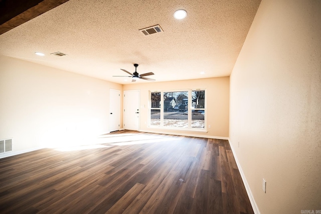 unfurnished room featuring visible vents, a ceiling fan, a textured ceiling, wood finished floors, and baseboards