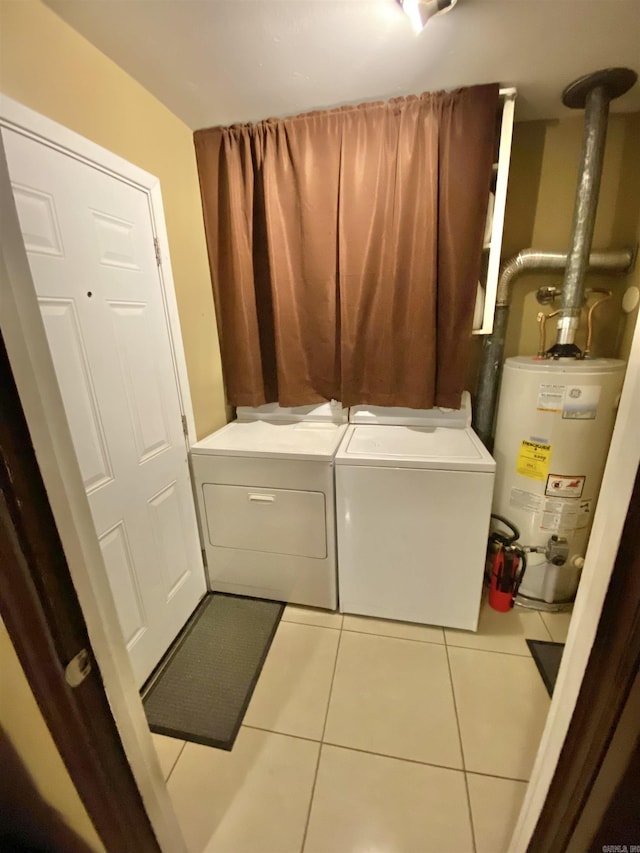 laundry area with tile patterned flooring, laundry area, gas water heater, and washing machine and clothes dryer