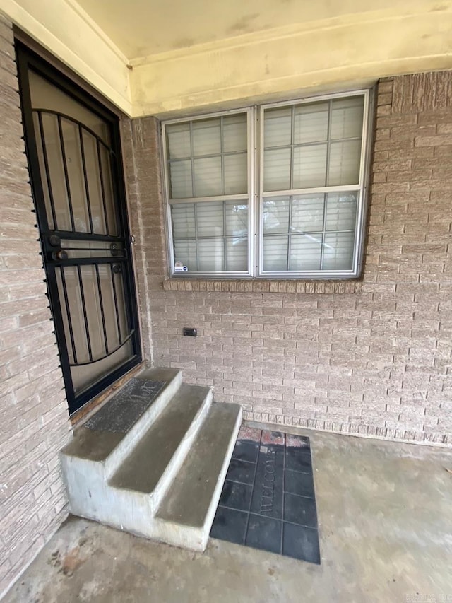 view of exterior entry featuring brick siding