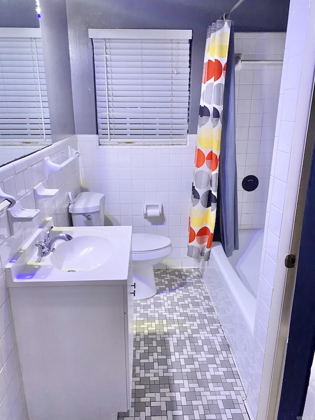 bathroom with vanity, tile patterned floors, toilet, and tile walls