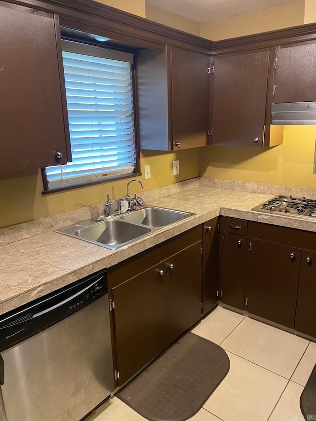 kitchen featuring a sink, light countertops, dark brown cabinets, under cabinet range hood, and appliances with stainless steel finishes