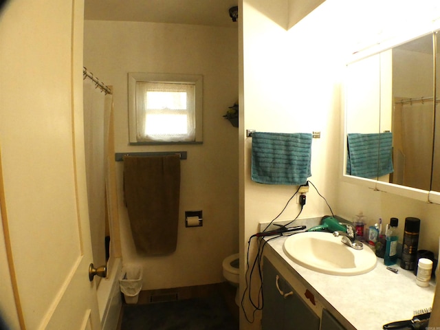 bathroom featuring toilet, a shower with shower curtain, and vanity