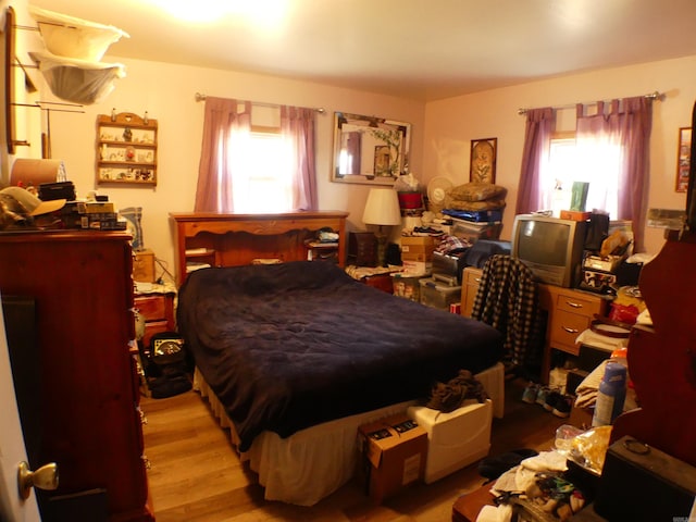 bedroom featuring multiple windows and wood finished floors