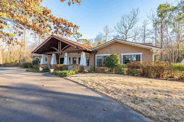 craftsman house with a porch and brick siding