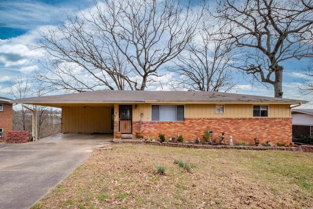 single story home featuring driveway, a front yard, a carport, and brick siding