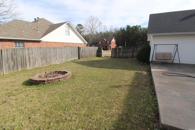 view of yard with a fire pit, a patio, and a fenced backyard