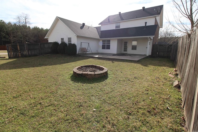 back of house featuring a fire pit, a yard, a patio area, and a fenced backyard