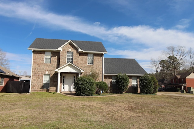 view of front facade with roof with shingles, brick siding, and a front lawn