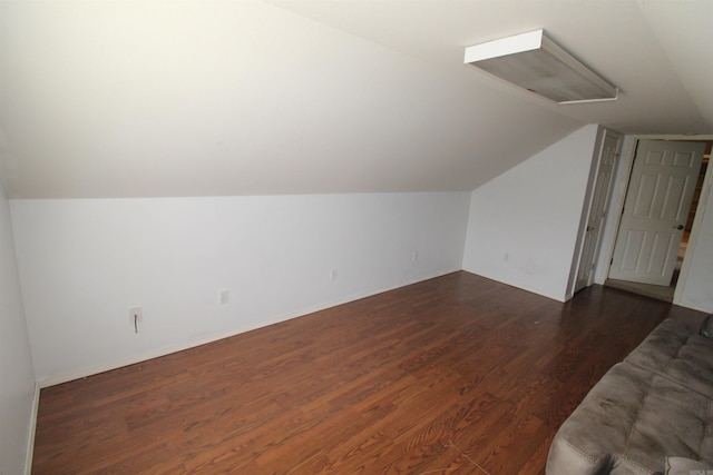 additional living space with dark wood-style floors and vaulted ceiling