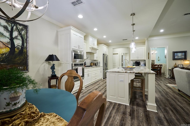 kitchen featuring dark wood finished floors, crown molding, stainless steel appliances, tasteful backsplash, and visible vents