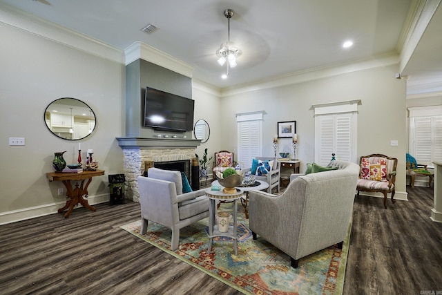 living room featuring a fireplace, visible vents, baseboards, ornamental molding, and dark wood finished floors