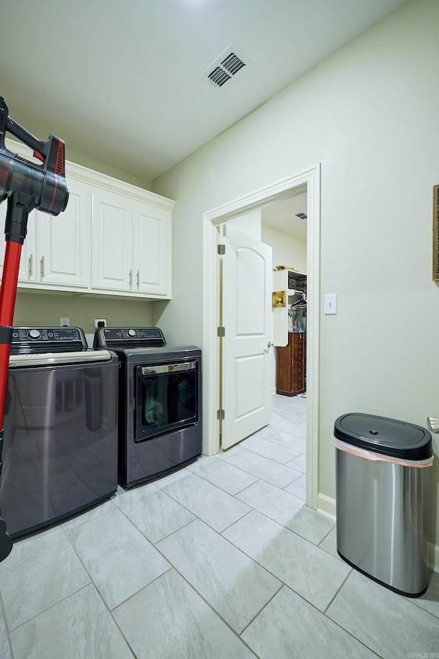 laundry area with cabinet space, light tile patterned floors, visible vents, and washer and dryer