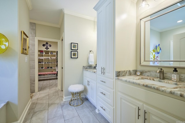 full bathroom featuring ornamental molding, a walk in closet, vanity, and baseboards