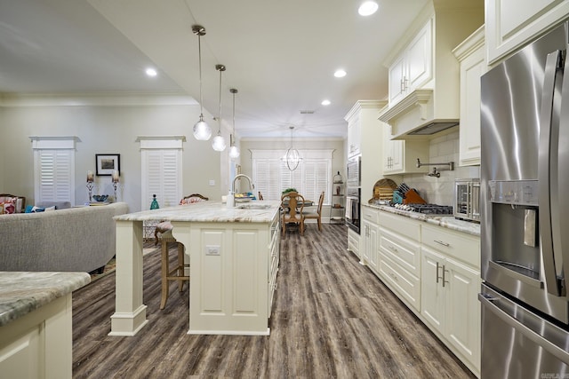 kitchen featuring dark wood finished floors, tasteful backsplash, appliances with stainless steel finishes, ornamental molding, and a sink