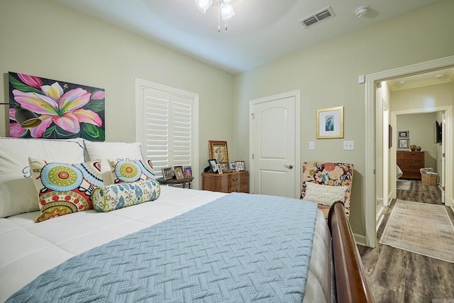 bedroom featuring wood finished floors, visible vents, and a ceiling fan