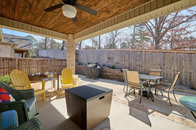 view of patio with a ceiling fan, outdoor dining space, a fenced backyard, and grilling area