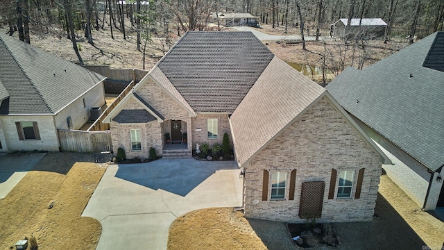 view of front facade with brick siding and a fenced backyard