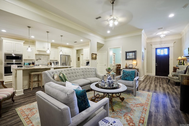 living room with recessed lighting, dark wood finished floors, visible vents, and crown molding