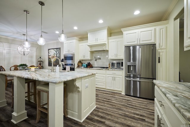 kitchen featuring crown molding, a breakfast bar area, stainless steel appliances, tasteful backsplash, and a sink