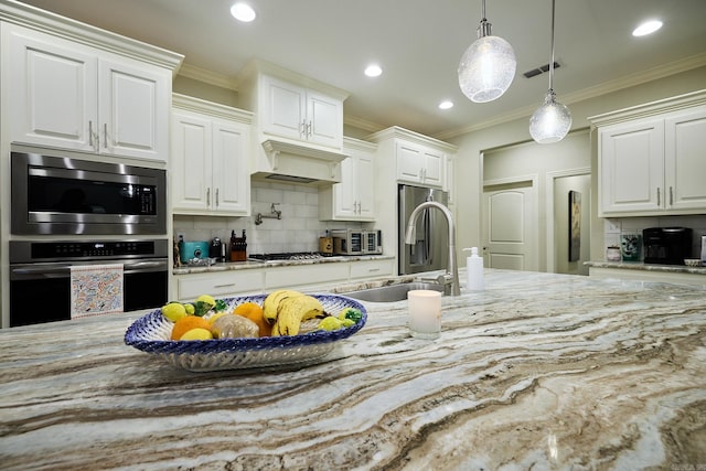 kitchen with a sink, visible vents, ornamental molding, custom exhaust hood, and light stone countertops