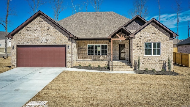 view of front of property featuring a garage, driveway, brick siding, and a front lawn