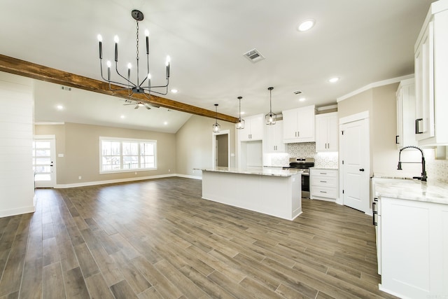 kitchen featuring tasteful backsplash, visible vents, stainless steel range with electric cooktop, a kitchen island, and a sink