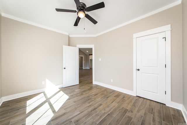 unfurnished bedroom with baseboards, wood finished floors, a ceiling fan, and crown molding