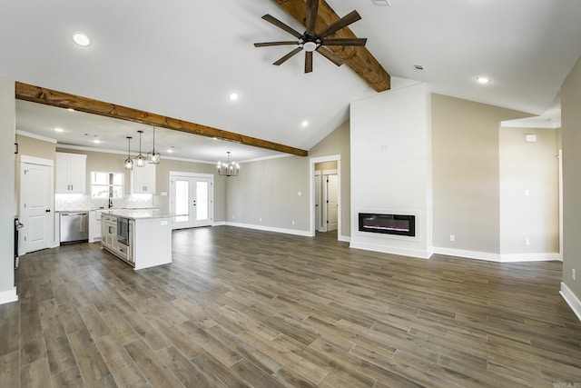 unfurnished living room with lofted ceiling with beams, a large fireplace, dark wood-style floors, and a sink